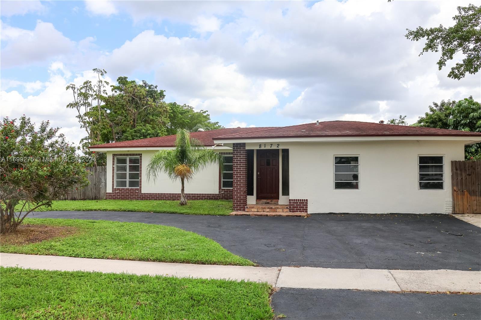 a front view of a house with a yard and trees