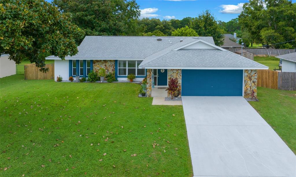 a aerial view of a house with table and chairs under an umbrella