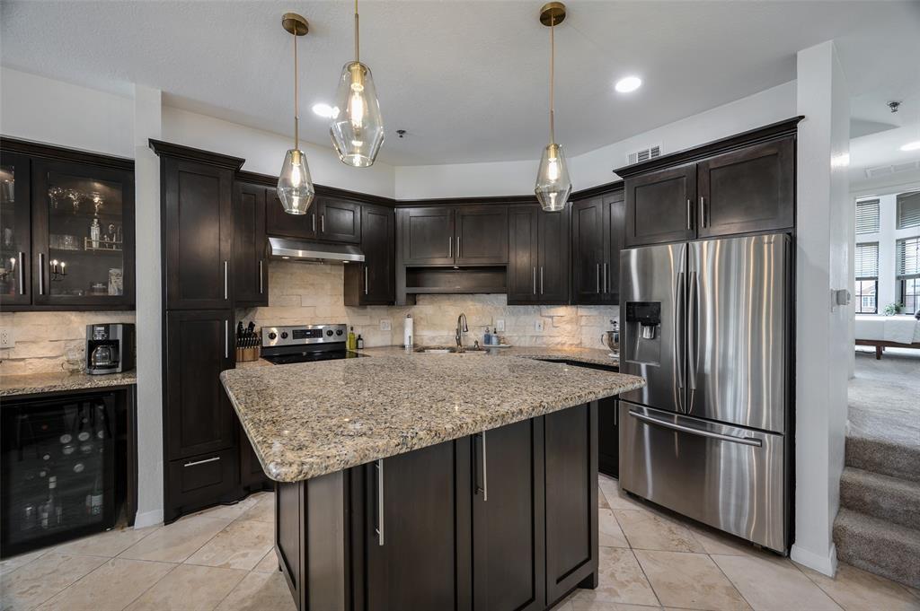 a kitchen with stainless steel appliances granite countertop a refrigerator a sink and a refrigerator