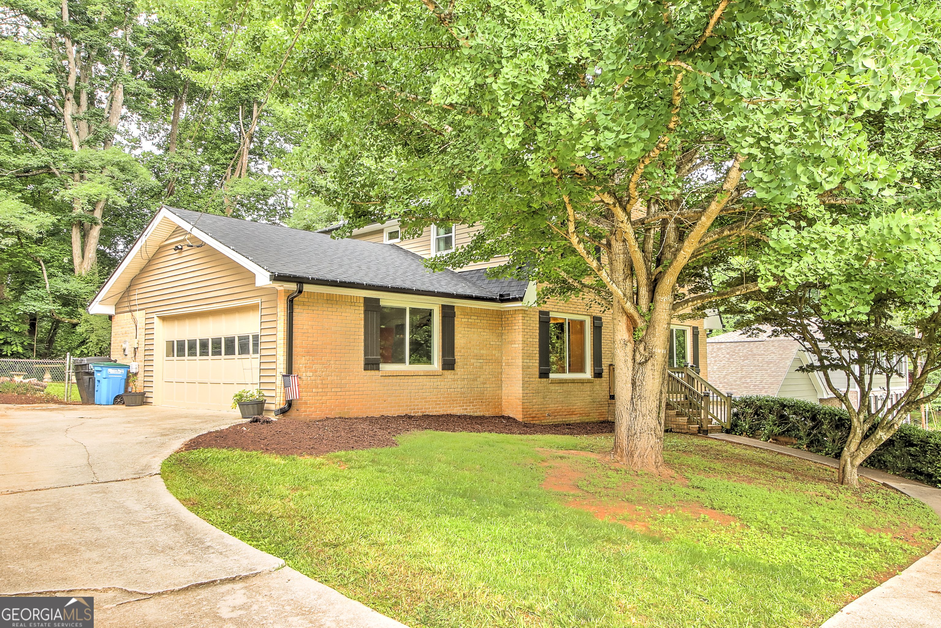 a view of a yard in front of a house with large trees