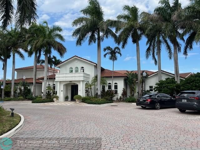 a front view of a house with a garden and palm trees