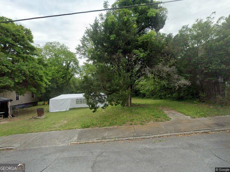 a view of a house with a yard and sitting area