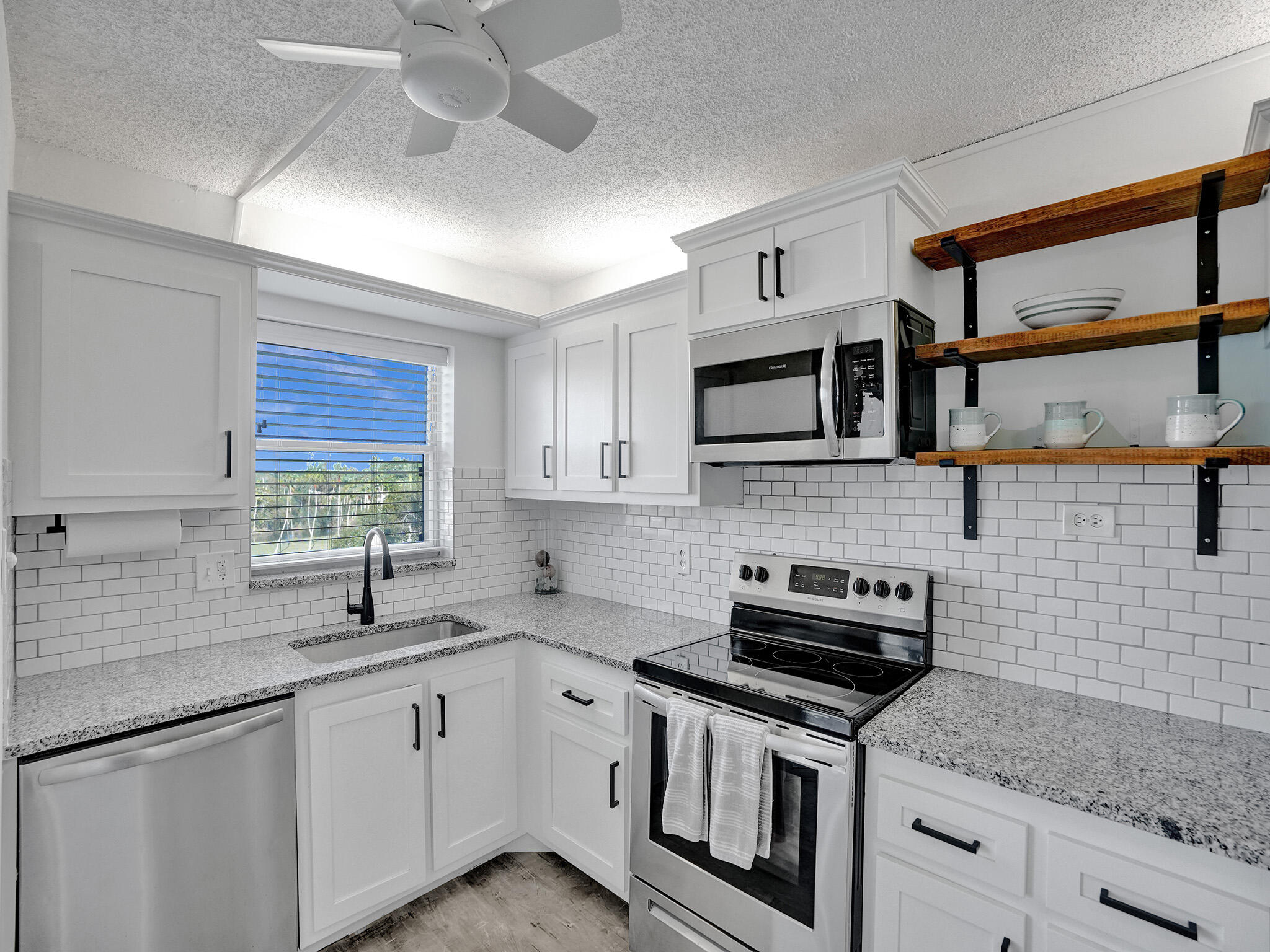 a kitchen with stainless steel appliances granite countertop a sink stove and microwave