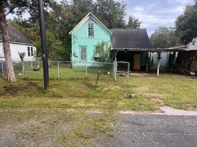 a view of house with backyard and trees in the background