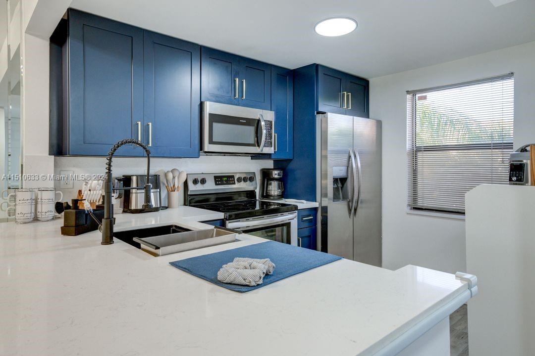 a kitchen with stainless steel appliances a refrigerator stove microwave and sink