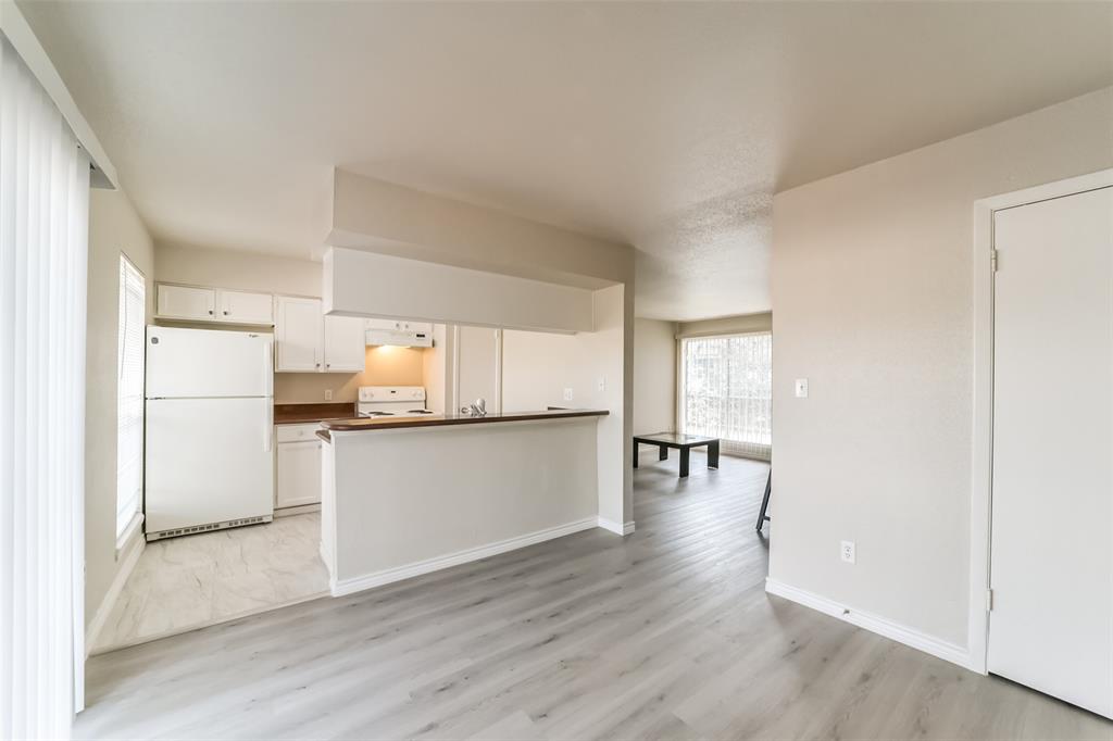 a kitchen with a refrigerator and wooden floor