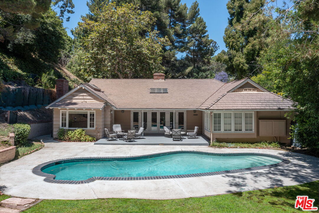 a view of a house with sitting area and swimming pool