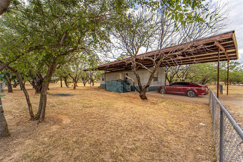 a view of a backyard patio with table and chairs under an umbrella