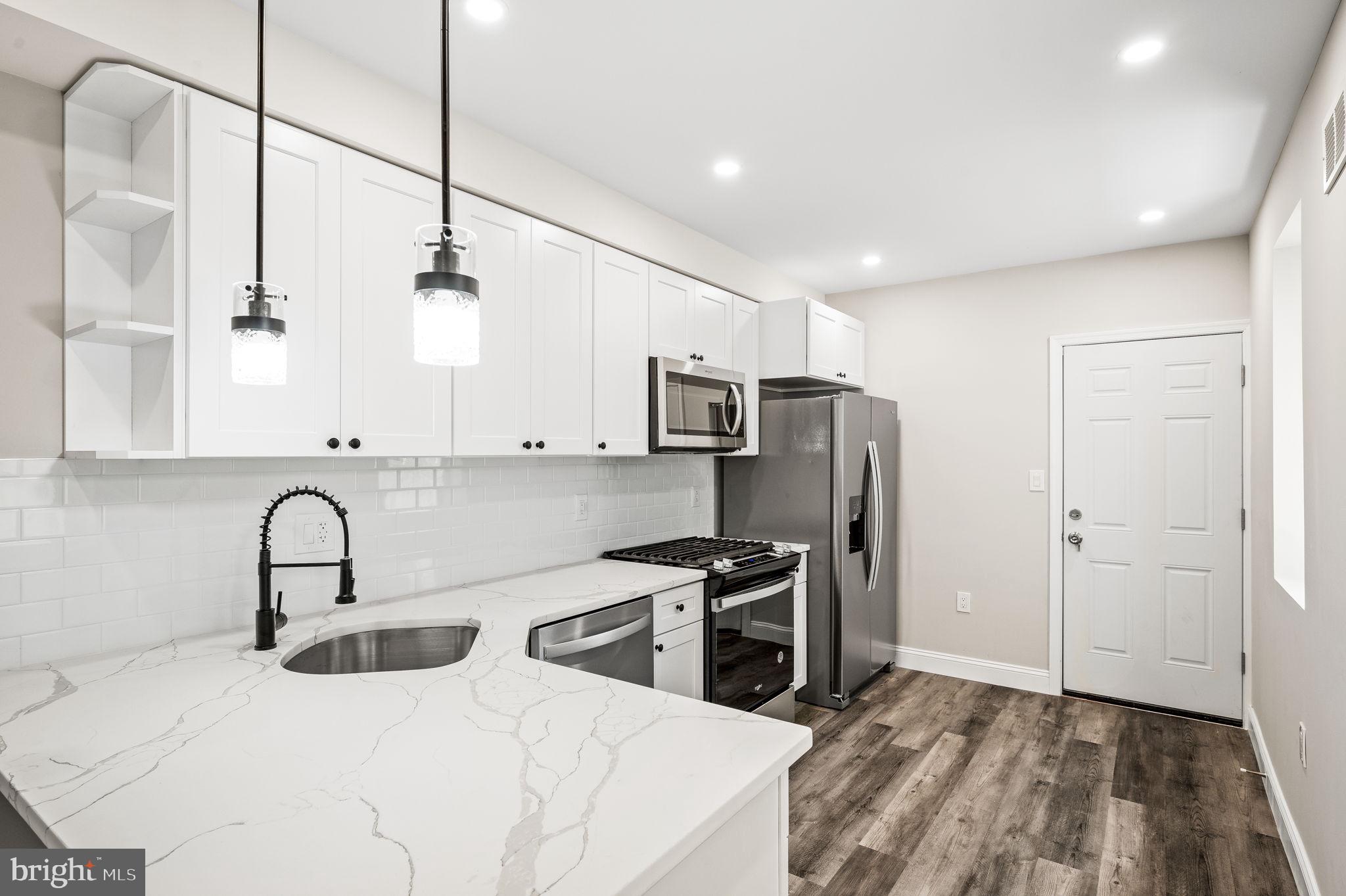 a kitchen with stainless steel appliances a refrigerator sink and cabinets