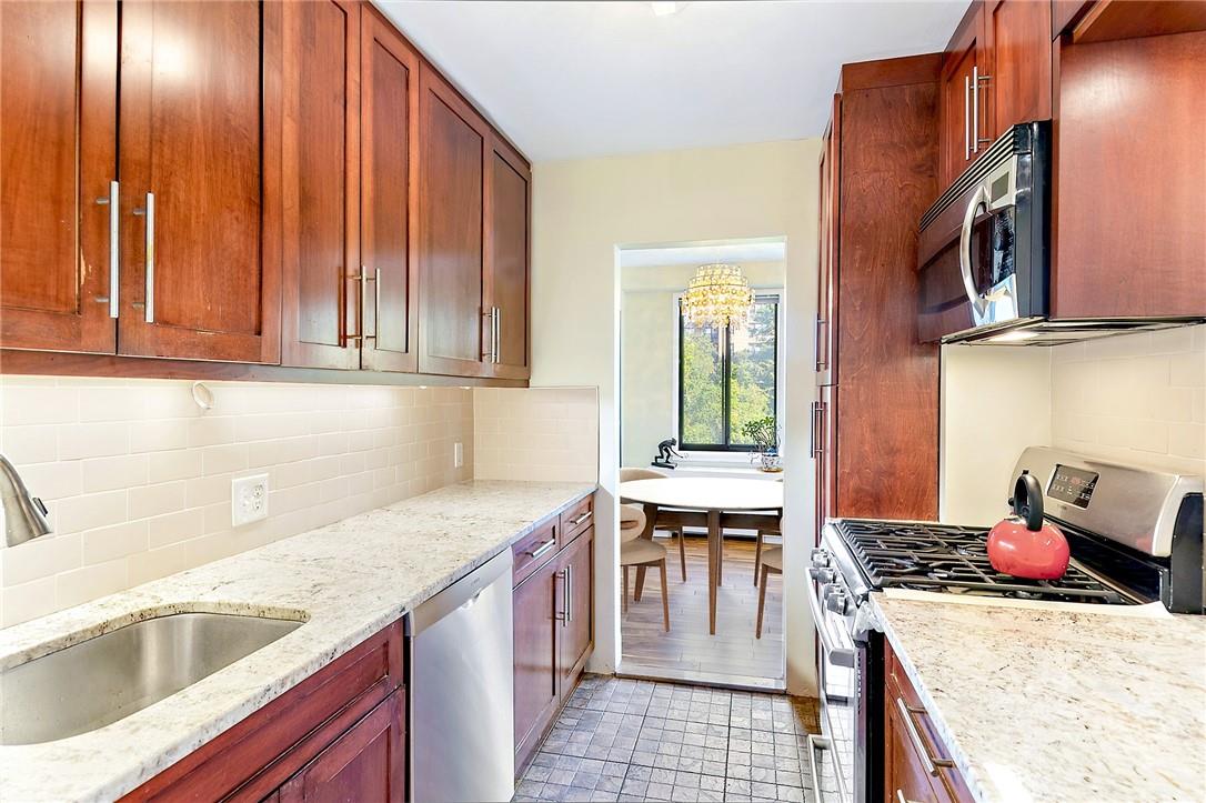 a kitchen with stainless steel appliances granite countertop a sink stove and cabinets