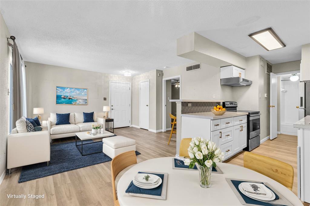 a living room with furniture and a dining table with kitchen view