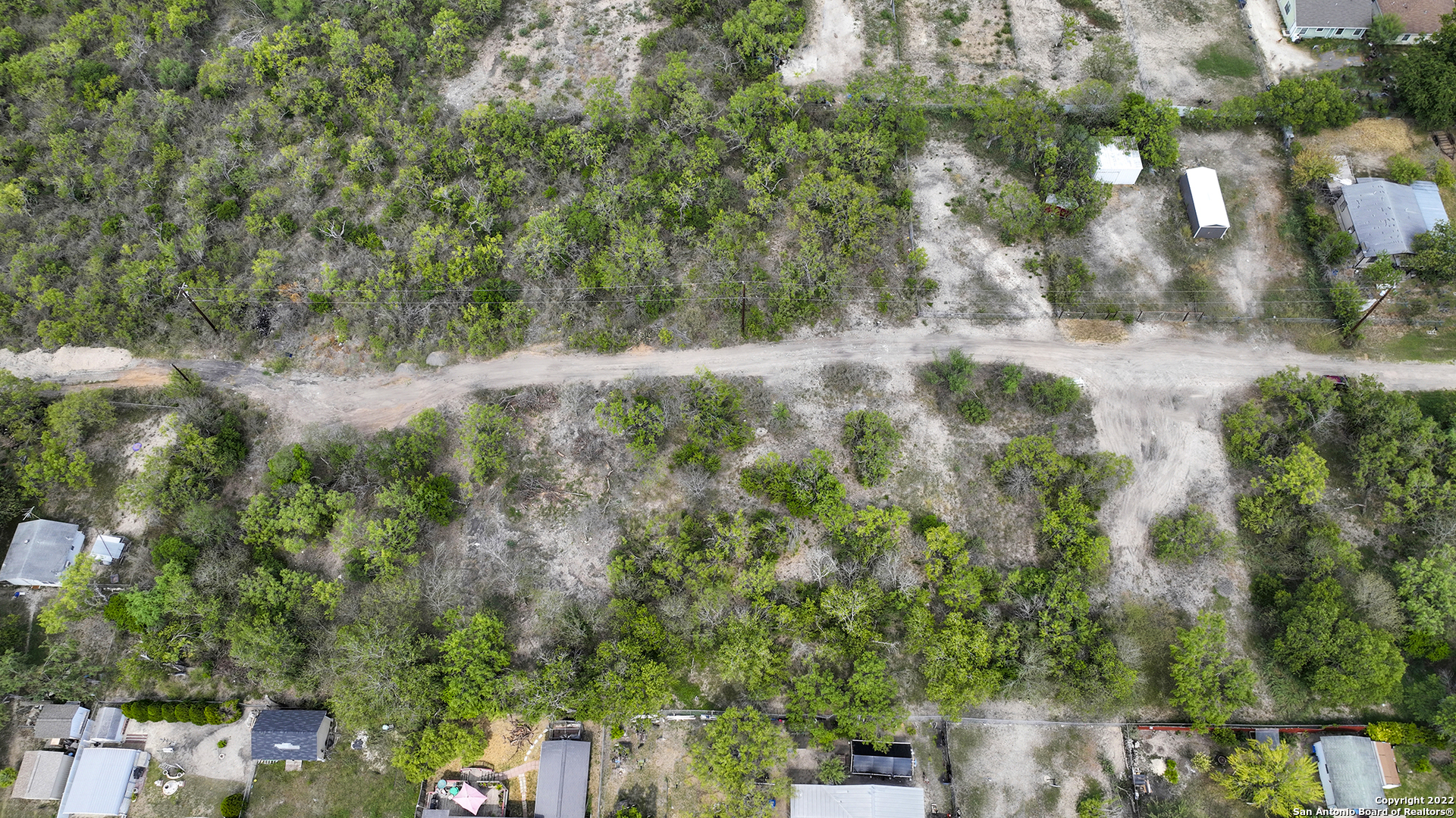 an aerial view of residential house with outdoor space and trees all around