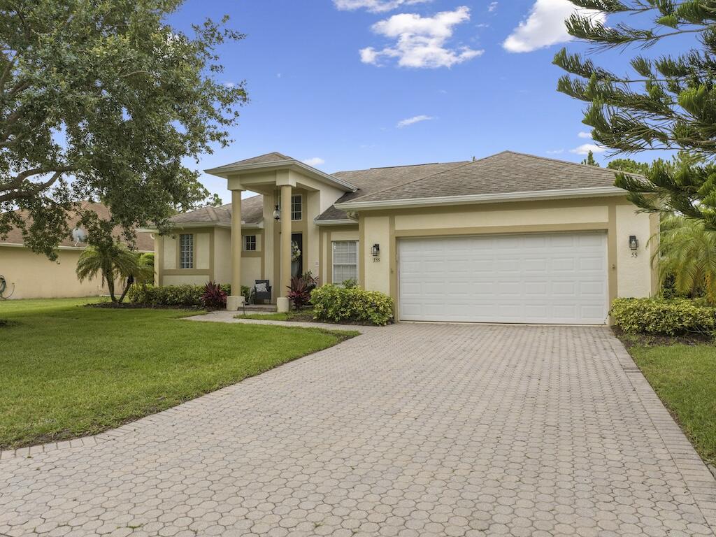 a front view of a house with a yard and a garage