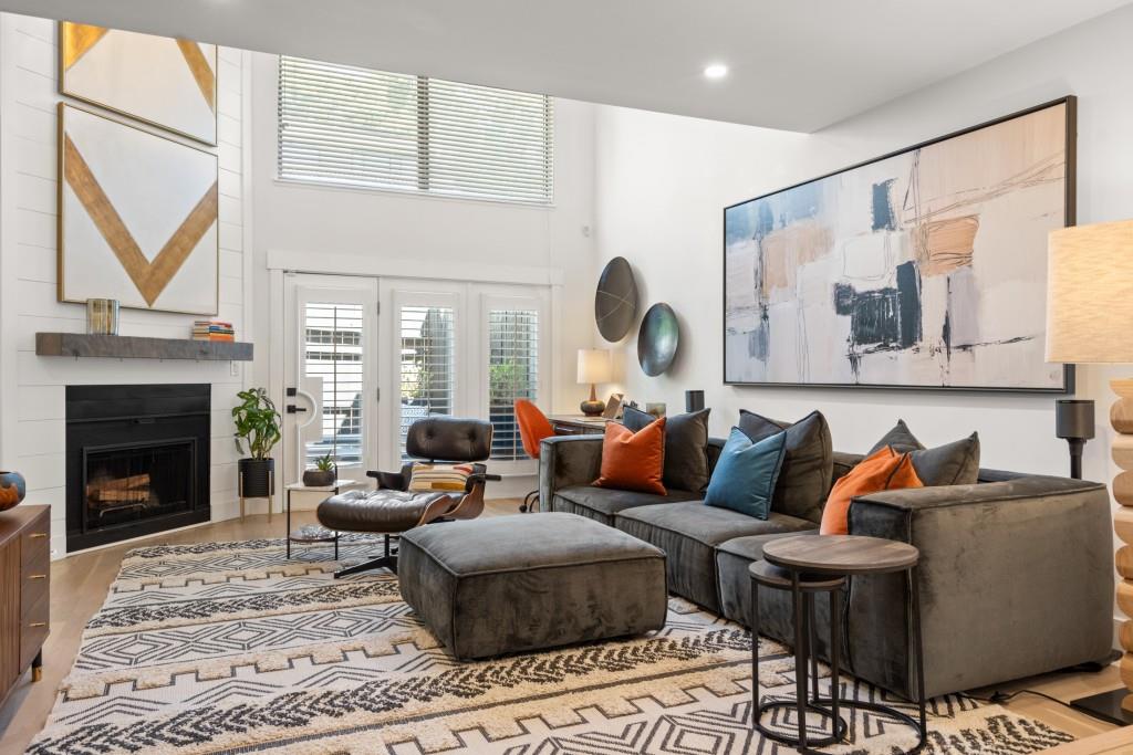 a living room with furniture a fireplace and a large window