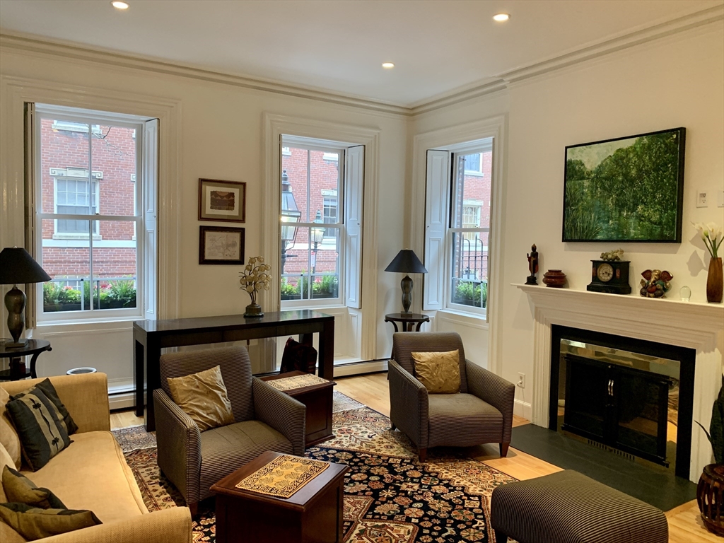 a living room with furniture a flat screen tv and a fireplace