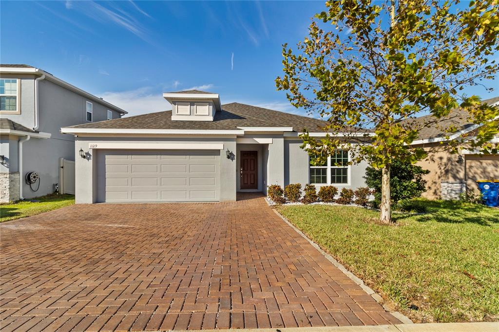 a front view of a house with a yard and garage