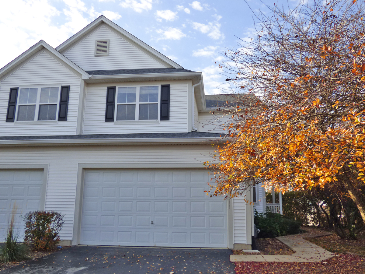 a front view of a house with a tree