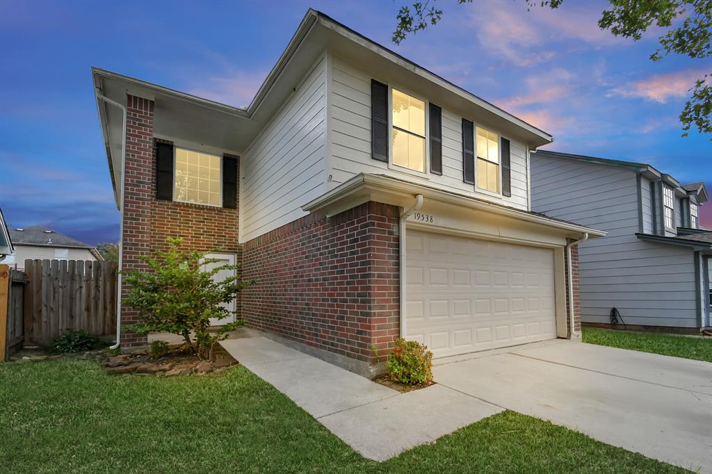 a front view of a house with a yard and garage