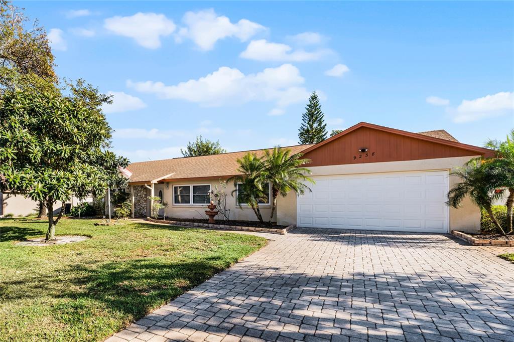 a front view of a house with a yard and trees