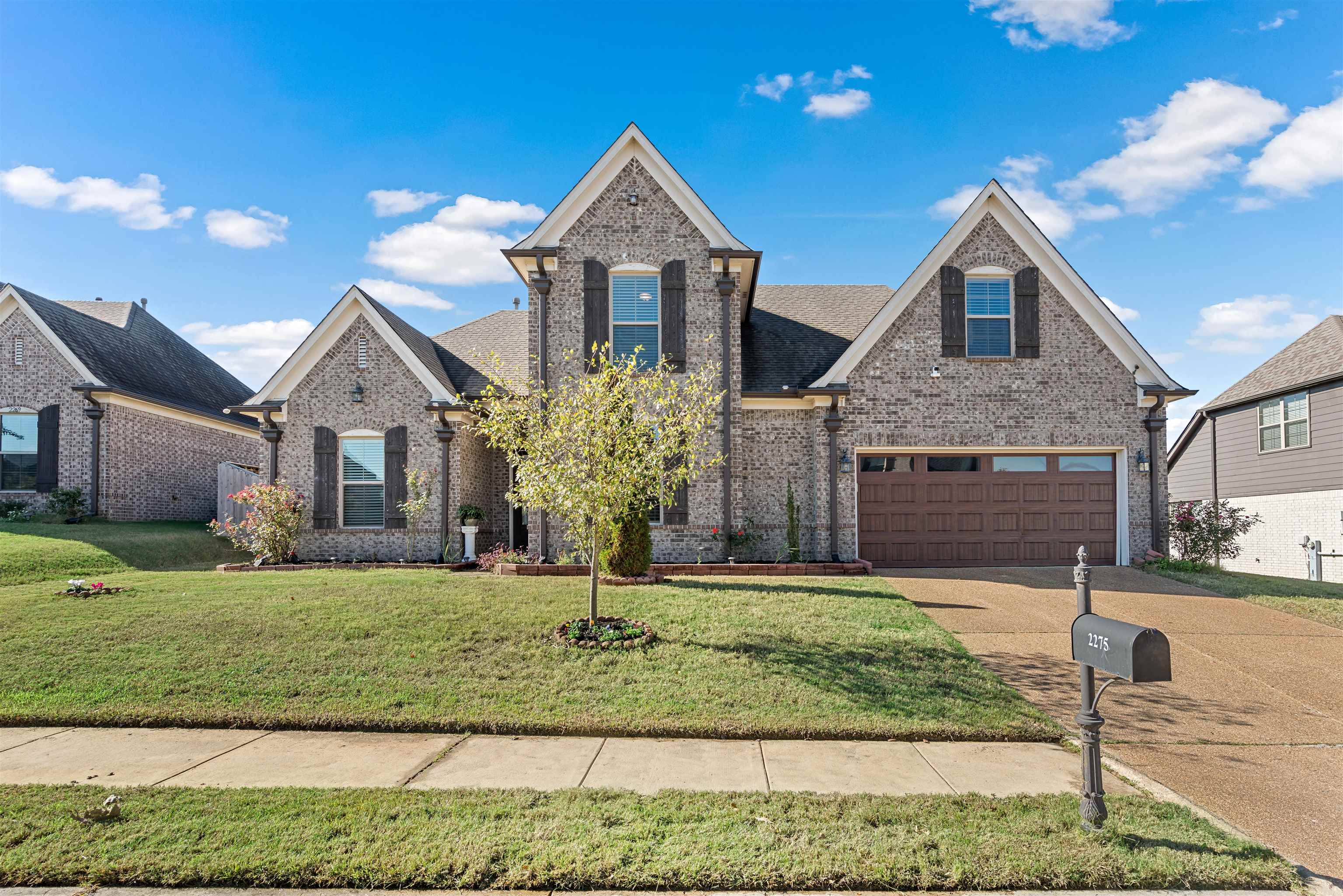 View of front of home with a garage and a front lawn