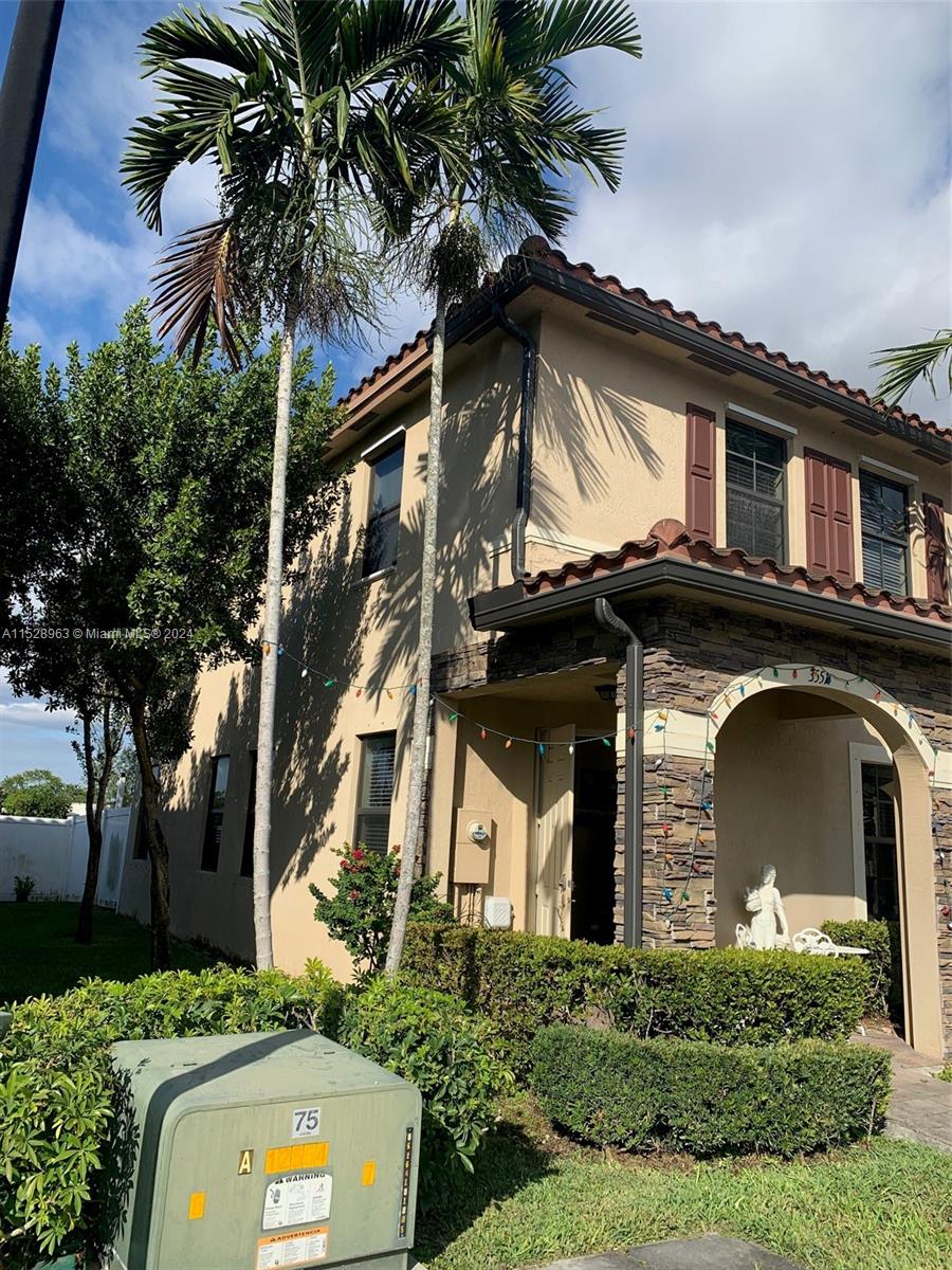 a front view of a house with a tree