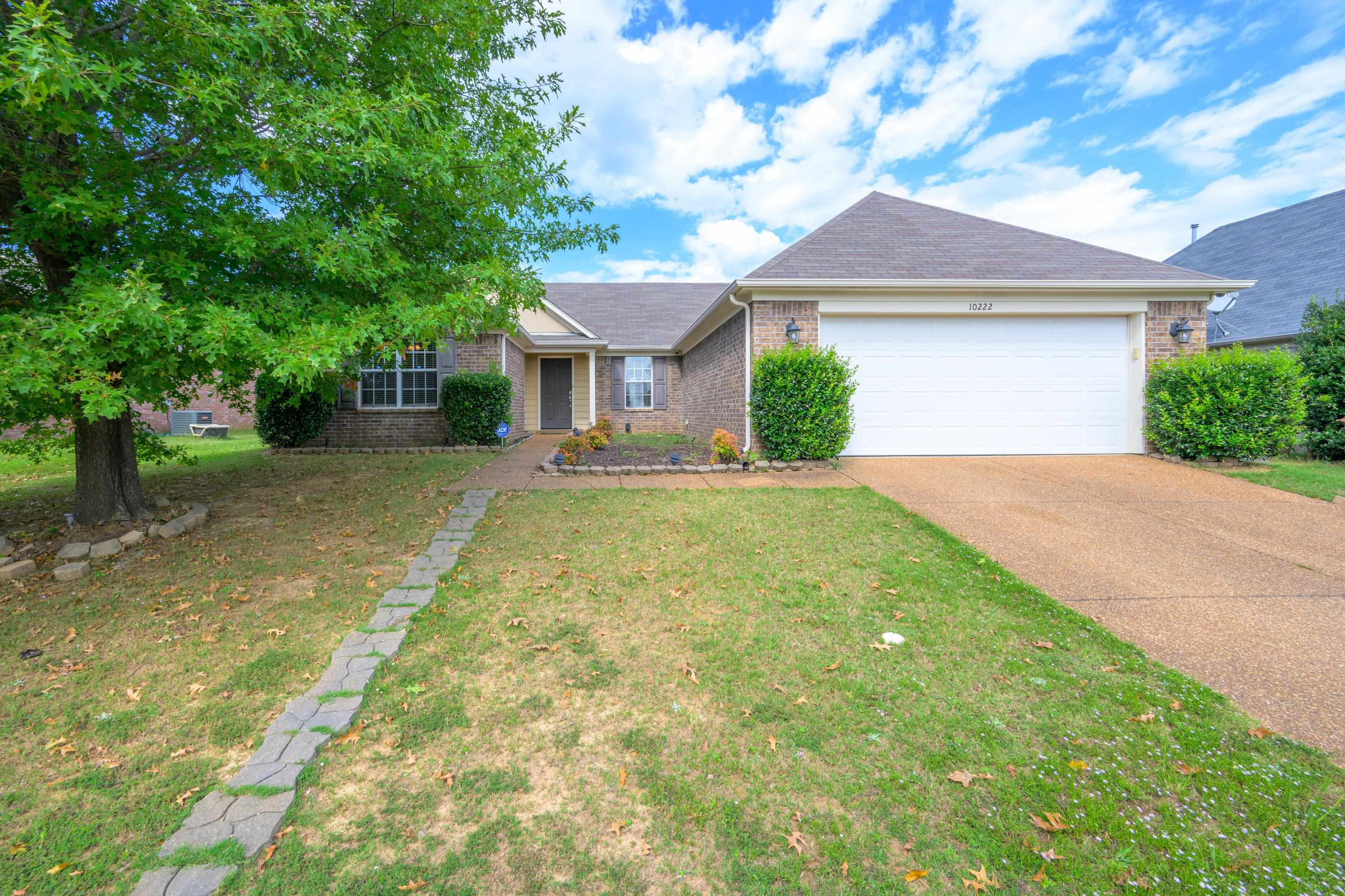 Ranch-style house with a front yard and a garage