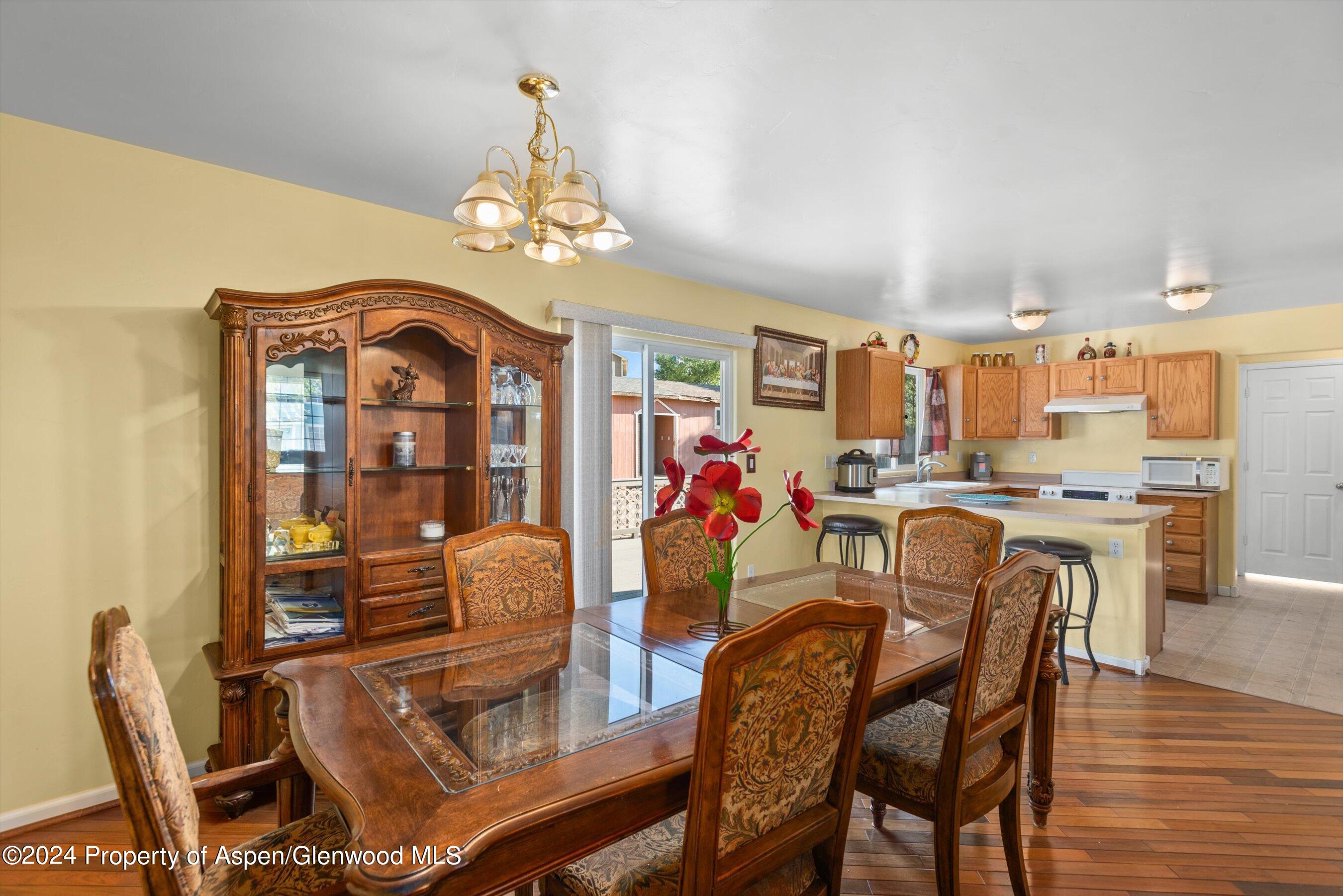 a dining room with furniture a chandelier and wooden floor