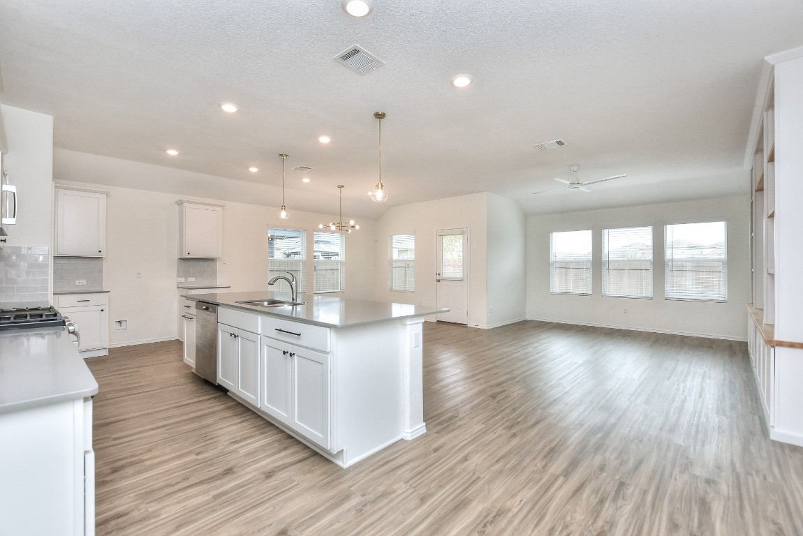 a large kitchen with stainless steel appliances granite countertop a large center island and a wooden floors