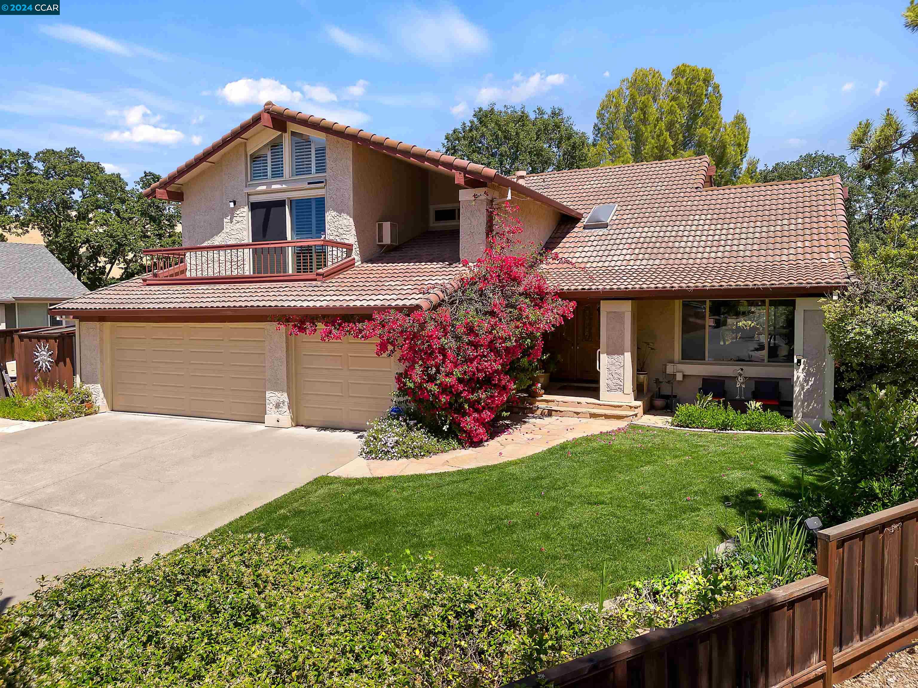 a front view of a house with a yard and potted plants