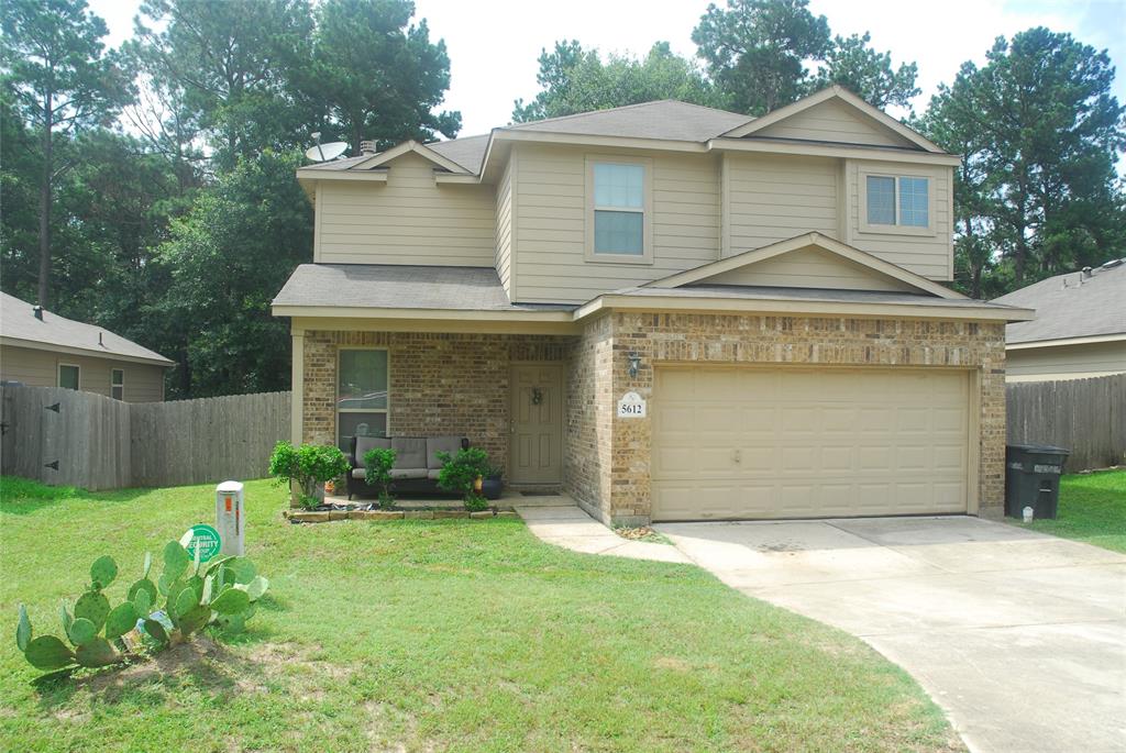 a front view of a house with a garden and garage