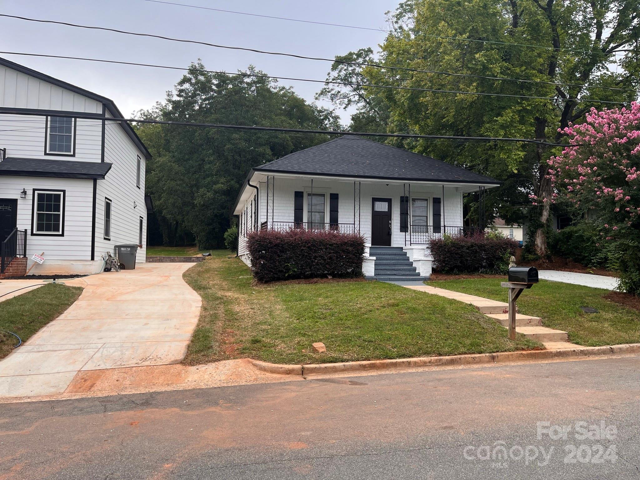 a front view of a house with a garden and yard