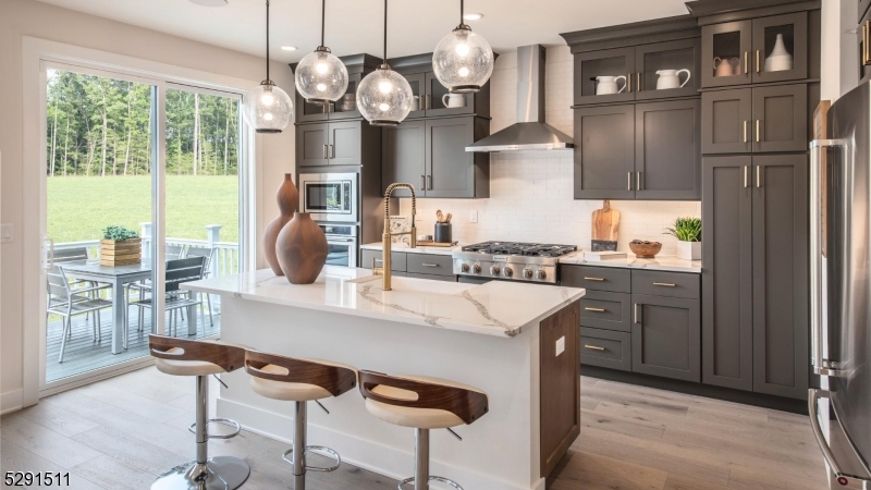 a kitchen with stainless steel appliances granite countertop a table chairs in it and wooden floors