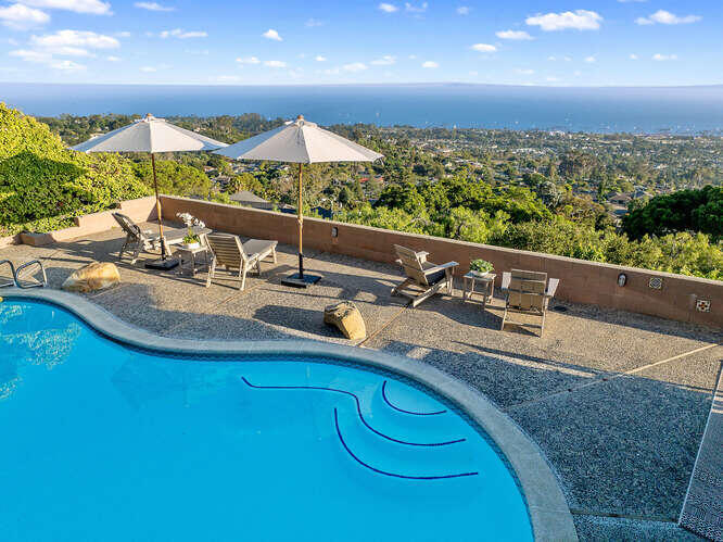 a view of a house with pool and chairs