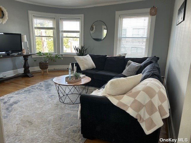 a living room with furniture a flat screen tv and a window