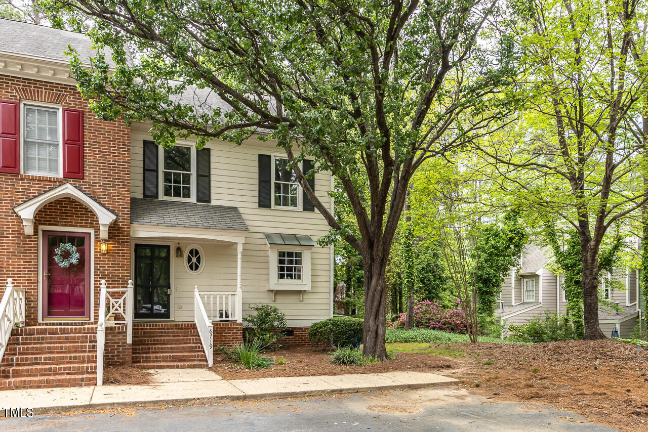 a front view of a house with a tree