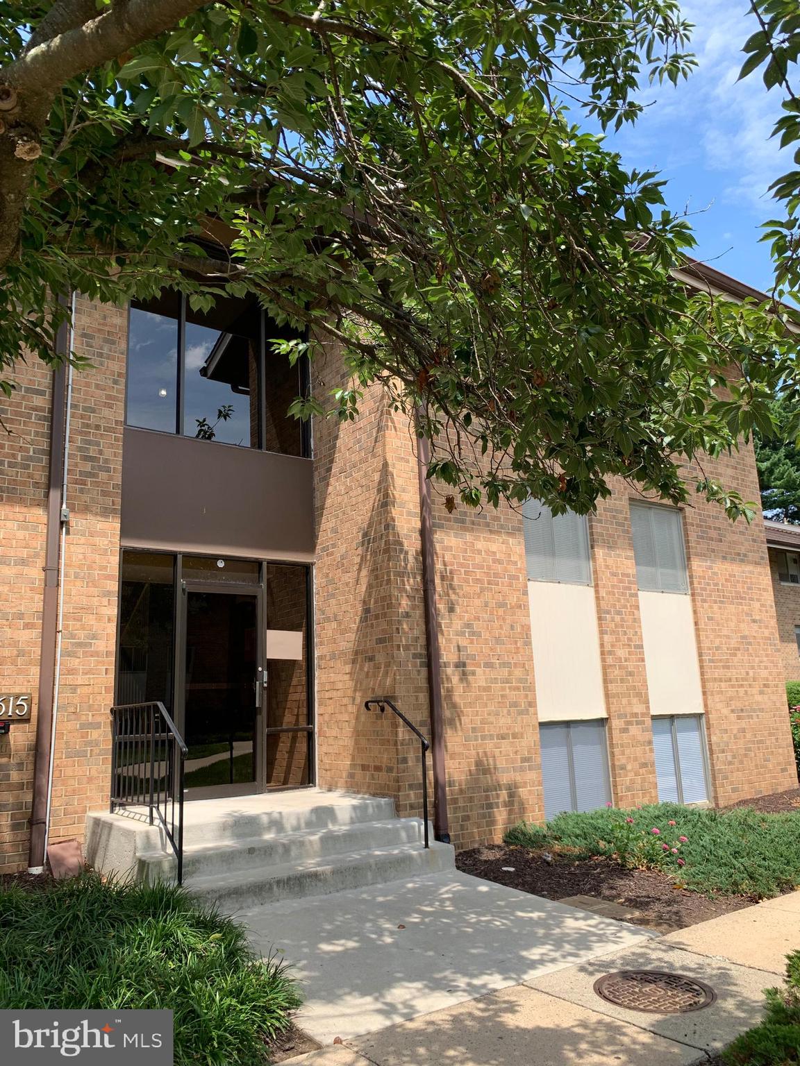 a view of a brick house with a tree in front of it