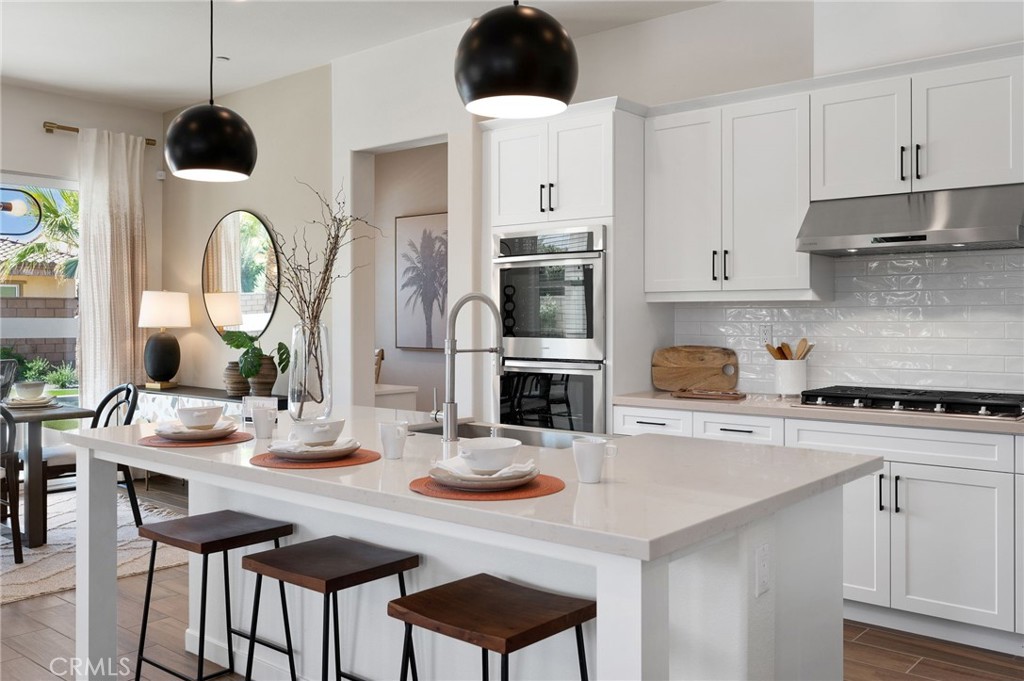 a kitchen with a table chairs stove and cabinets