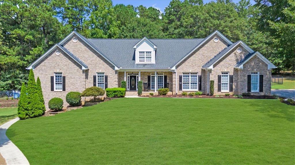 a front view of a house with a yard and green space