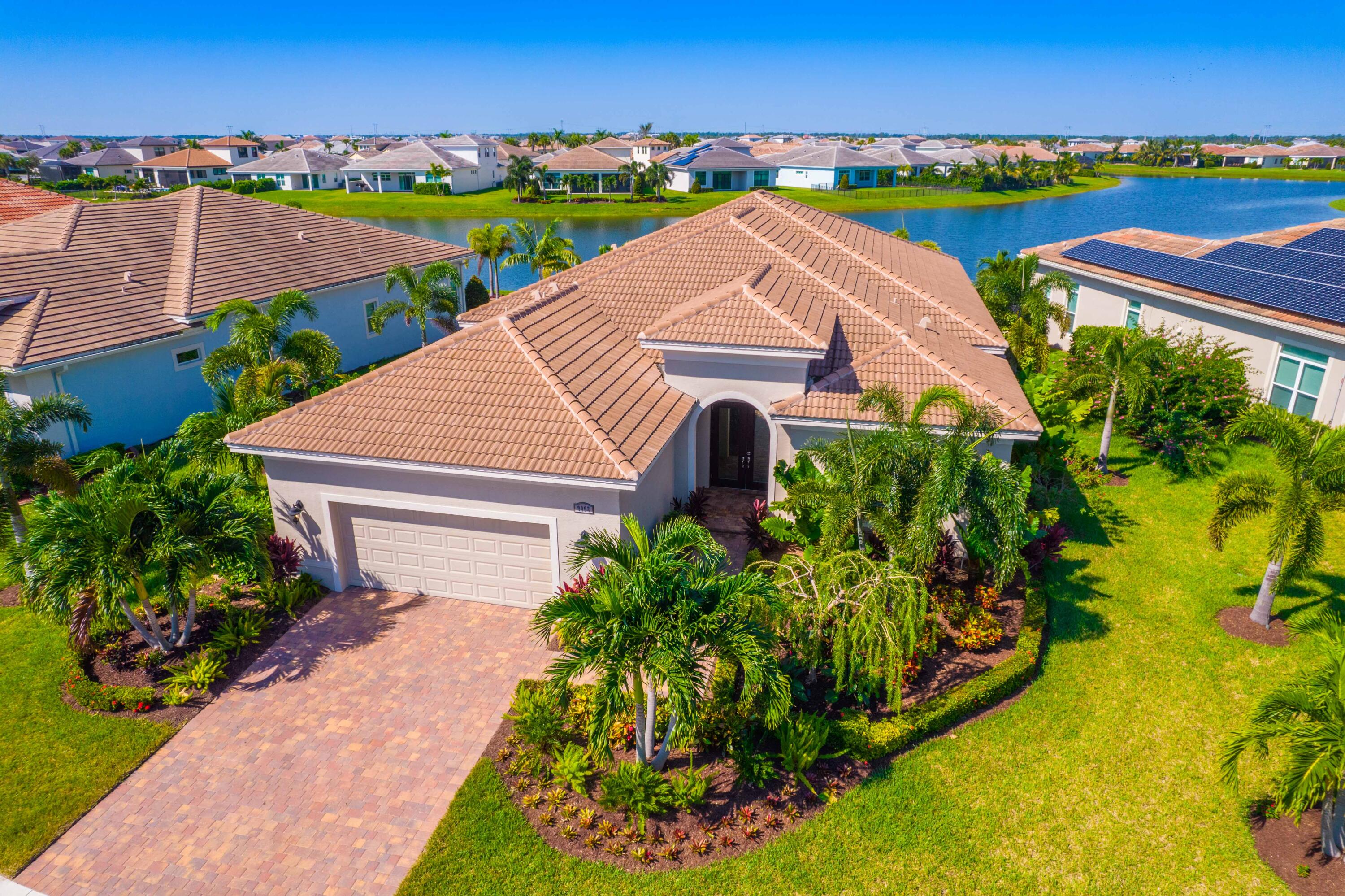 an aerial view of a house with a garden and lake view