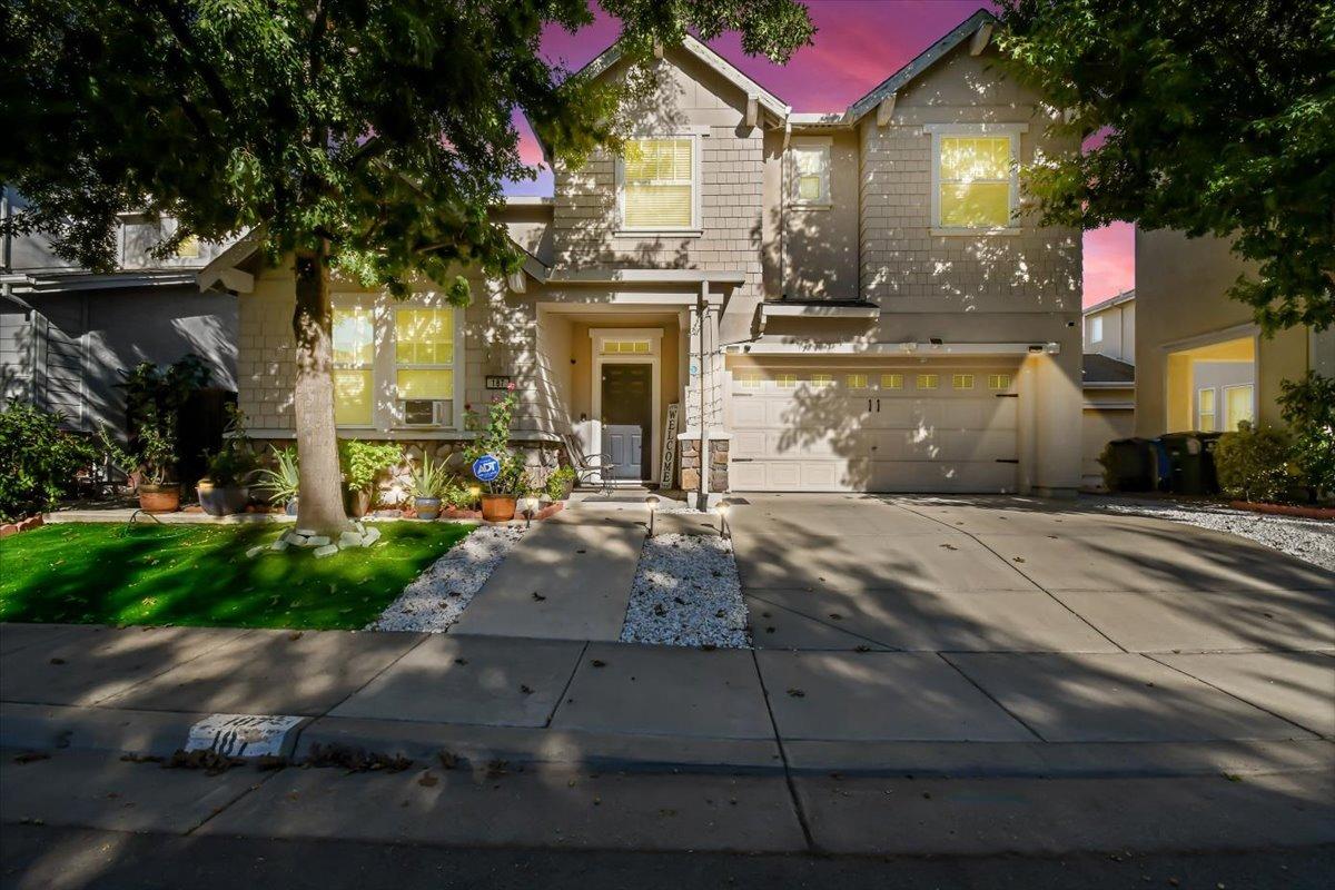 a front view of a house with yard and parking