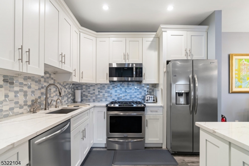 a kitchen with stainless steel appliances and white cabinets