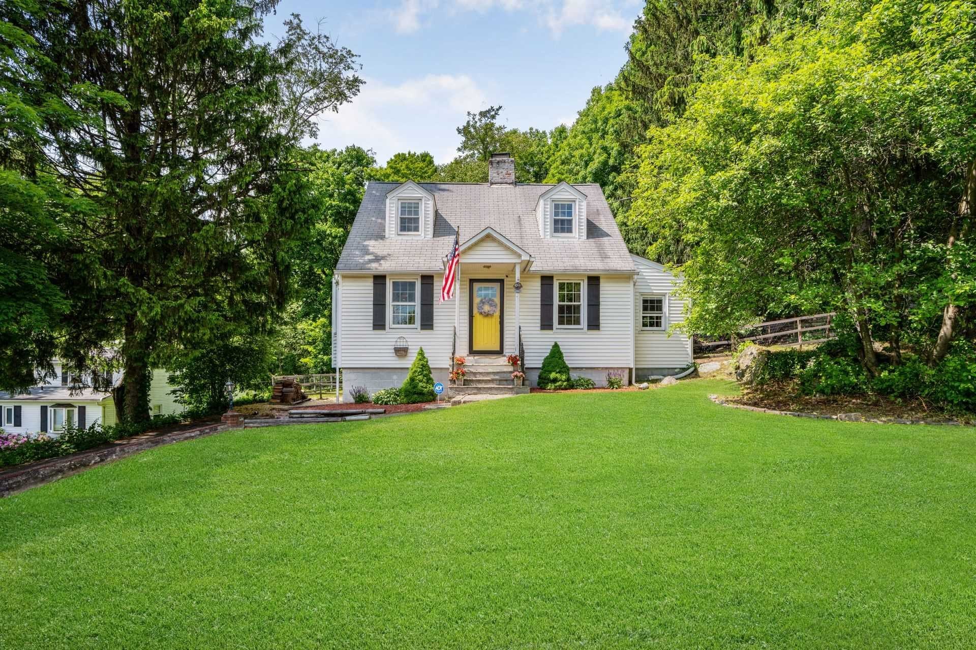 a front view of a house with a garden and yard