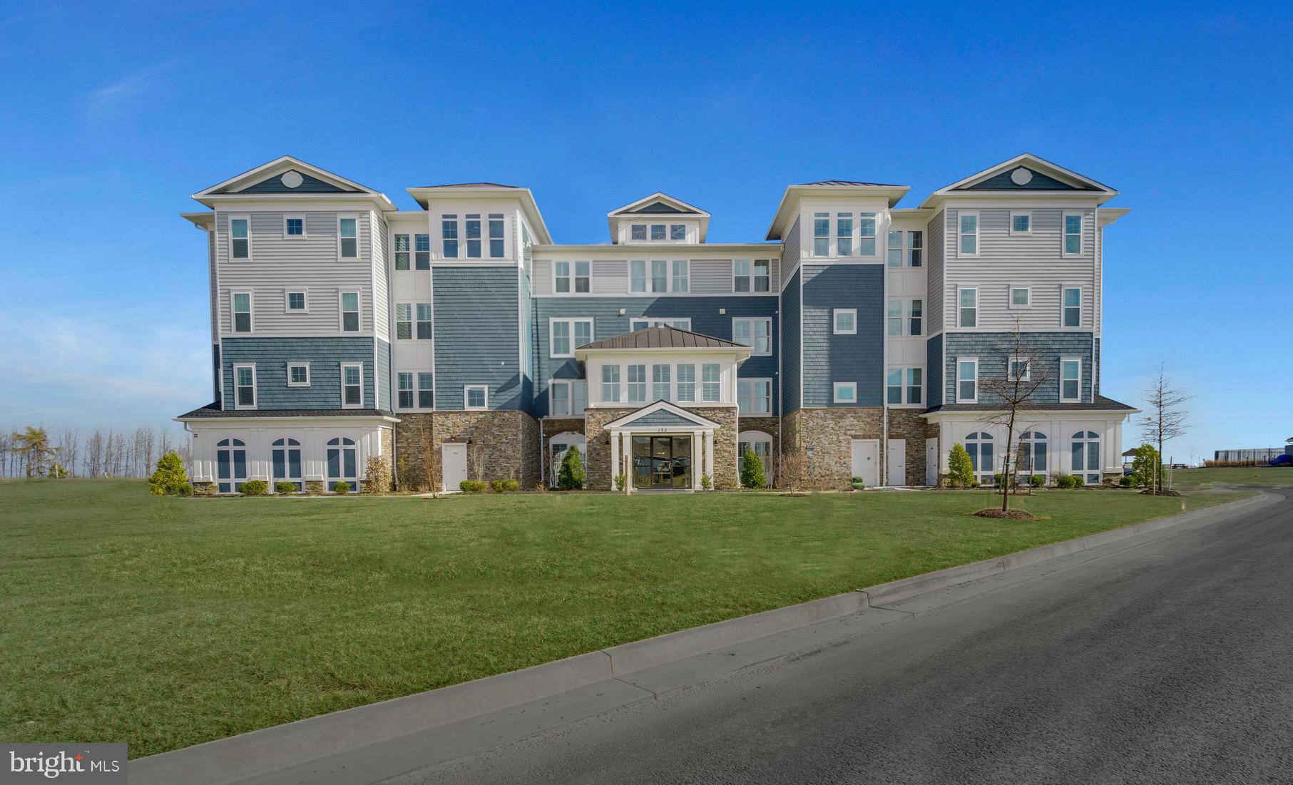 a front view of a residential apartment building with a yard