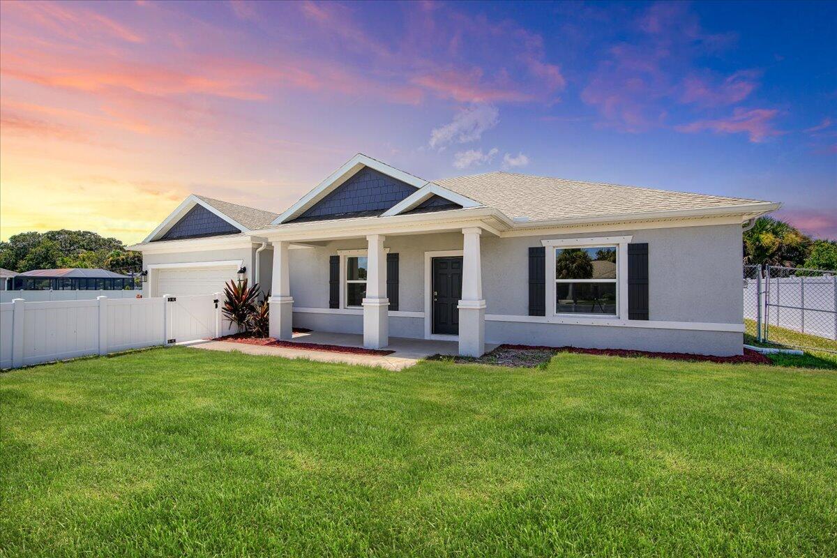 a front view of a house with a garden and yard