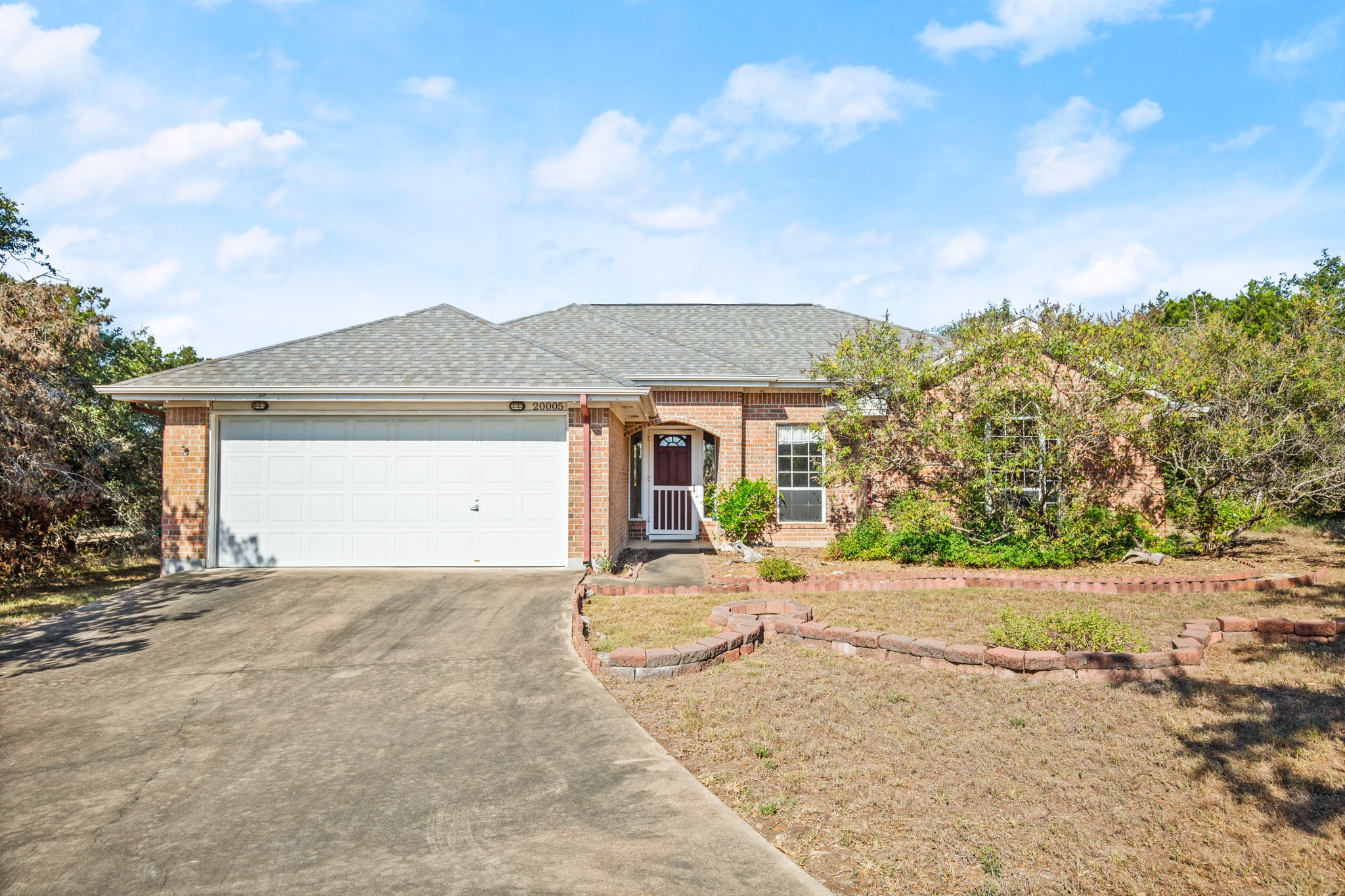 front view of a house with a dirt yard and a garage