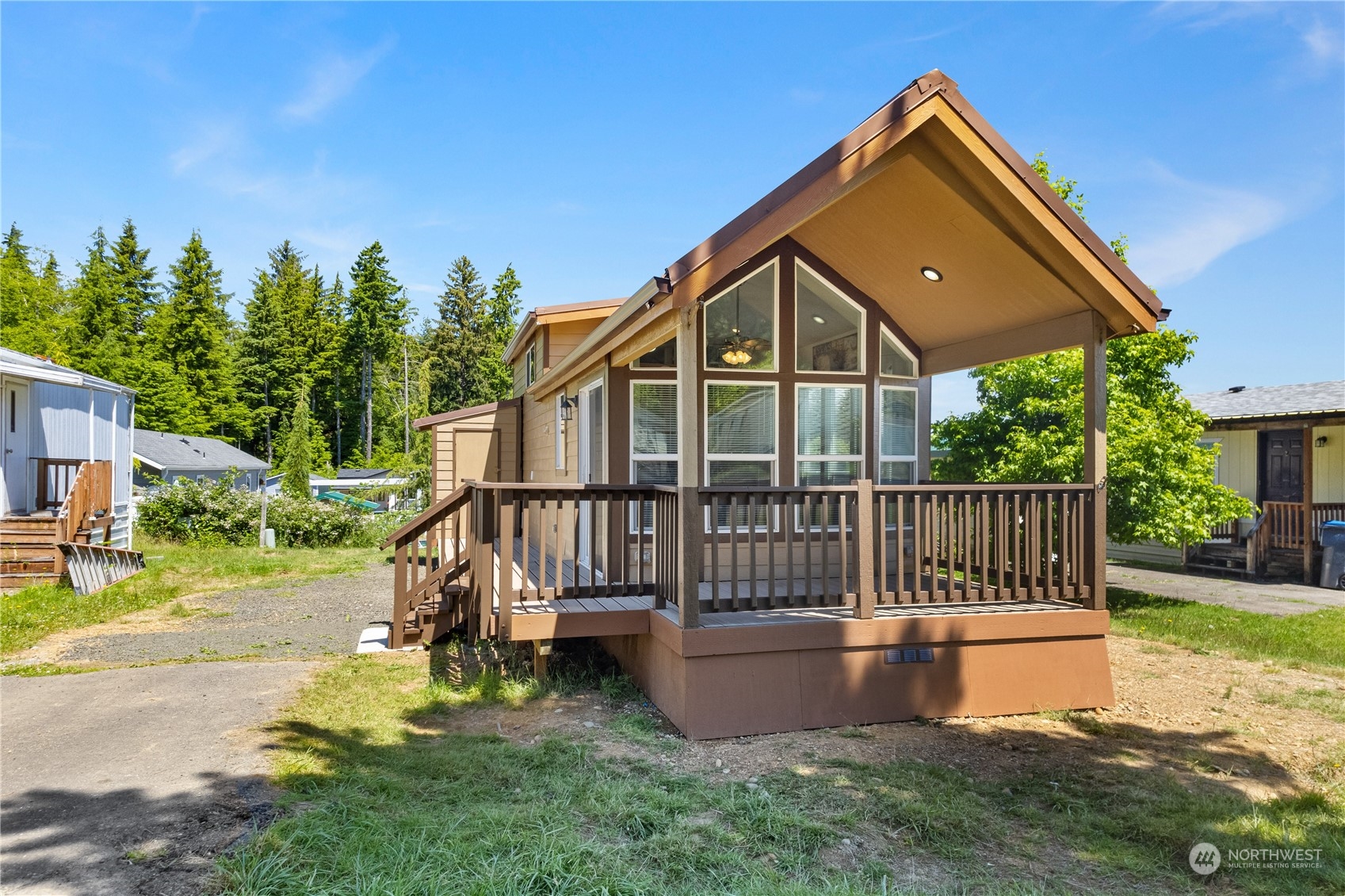 a view of a house with a wooden deck and a yard