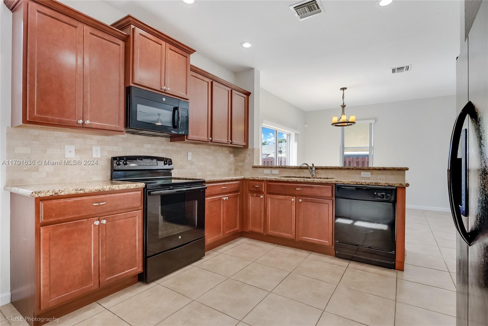 a kitchen with stainless steel appliances granite countertop a refrigerator and a stove top oven