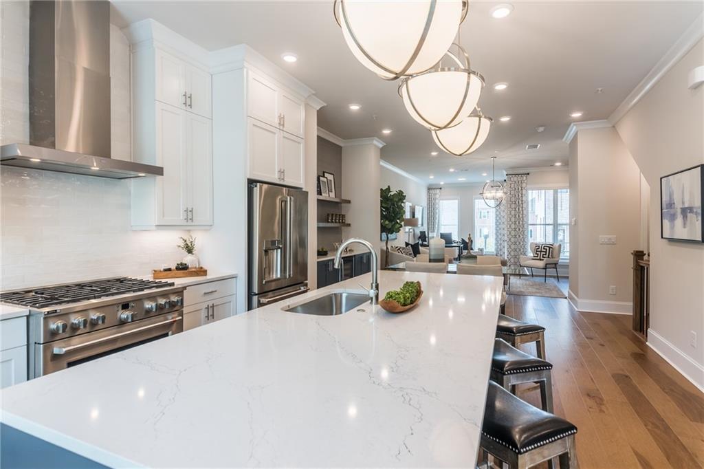 a kitchen with stainless steel appliances a table chairs and a refrigerator