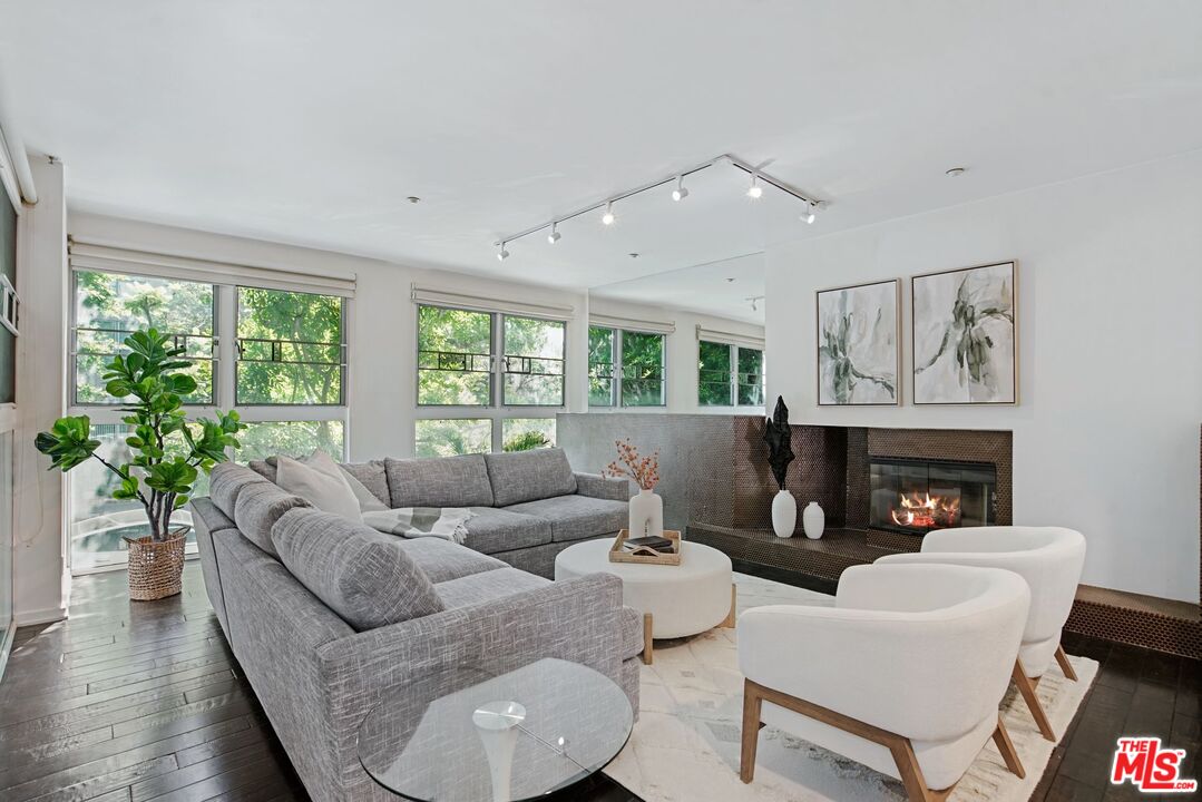 a living room with furniture a fireplace and a potted plant