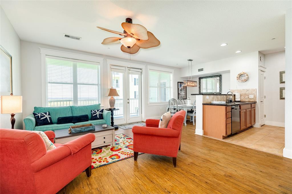 a living room with furniture kitchen view and a large window